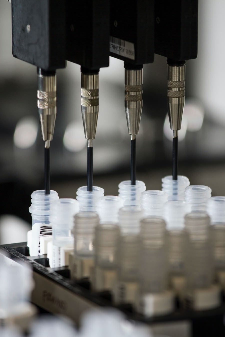 Close up of machine putting genetic liquid into small containers